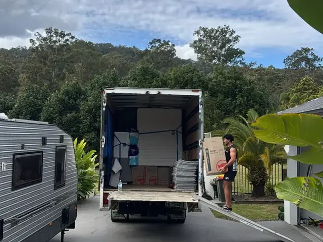 Safepack removalist carrying a box into the back of a loaded removal truck