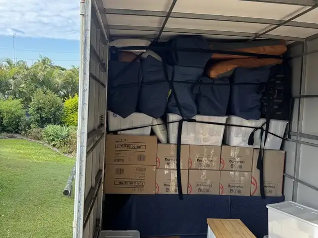 Boxes and furniture carefully packed inside a Safepack removal truck, with garden views outside