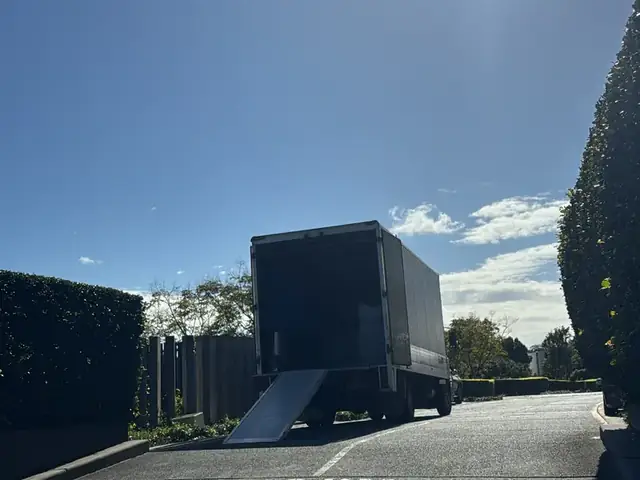 Safepack removal truck driving into the sun on a Gold Coast road